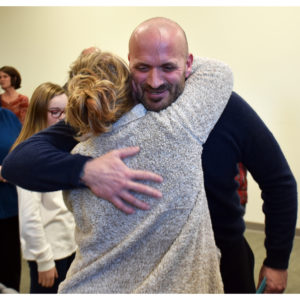 Christopher Ruggles receives a congratulatory hug at his graduation from the Merrimack County Drug Court in Concord on January 28. He was the first person to graduate from the program.